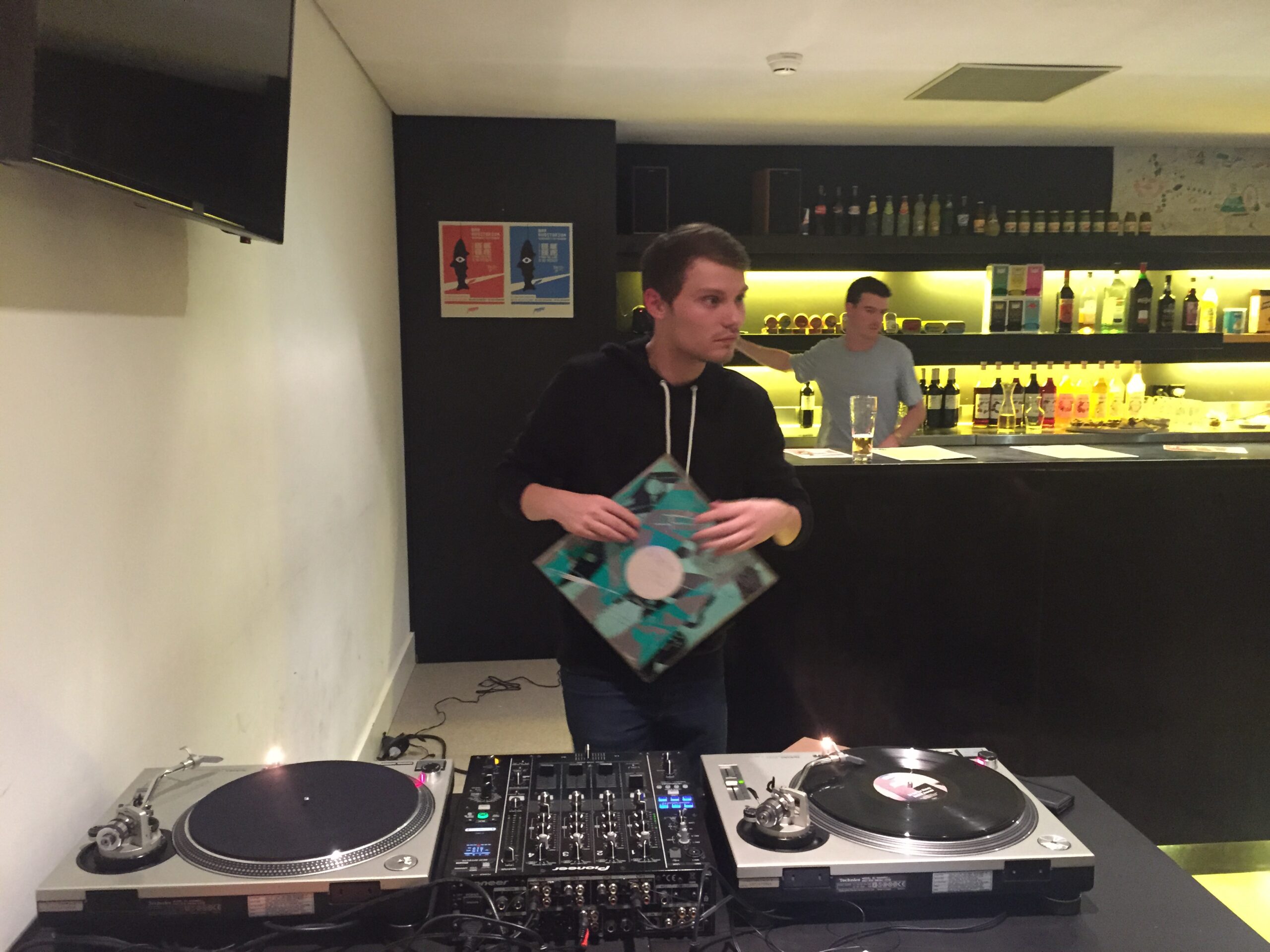 photo du bar auditorium de Poitiers. on y voit un homme tenant un vinyle devant des platines